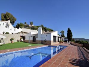 eine Villa mit einem Pool vor einem Haus in der Unterkunft Belvilla by OYO Casa Loli in Algarrobo-Costa