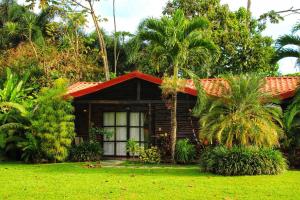 una pequeña casa de madera con techo rojo en Casona Rústica & Bungalow, en Fortuna