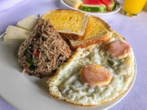 a plate of food with eggs and bread and rice at Casona Rústica & Bungalow in Fortuna