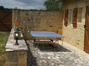 eine Tischtennisplatte vor einer Steinmauer in der Unterkunft Holiday home with pool, enclosed garden in Saint-Pompont