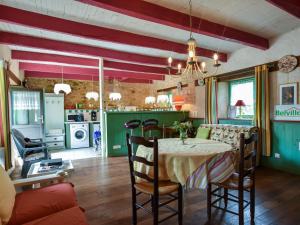 a dining room with a table and a kitchen at Cosy holiday home with terrace near Quimperl in Coatviller