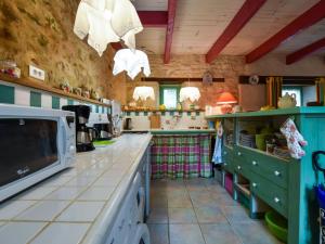 une grande cuisine avec un comptoir et un four micro-ondes dans l'établissement Cosy holiday home with terrace near Quimperl, à Coatviller