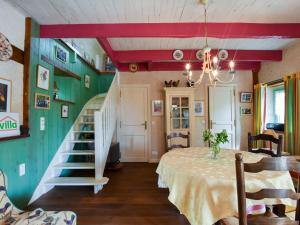 une salle à manger avec une table et un escalier dans l'établissement Cosy holiday home with terrace near Quimperl, à Coatviller