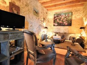 a living room with a television and a table with chairs at Cozy House in Lot with Pool and Terrace in Saint-Caprais-de-Lerm
