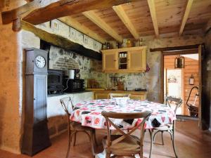 a kitchen with a table and a clock on the wall at Cozy House in Lot with Pool and Terrace in Saint-Caprais-de-Lerm