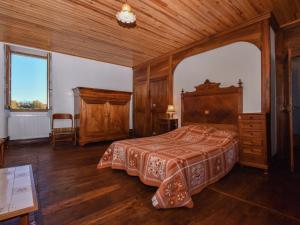 sypialnia z łóżkiem i drewnianym sufitem w obiekcie Beautiful holiday home near the forest w mieście Montfaucon