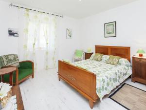 a bedroom with a bed and a green chair at Family Stay in Scenic Cazals in Cazals
