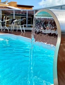 una fuente de agua en una piscina en Pousada Morada do Sol, en Maragogi