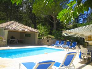 un grupo de sillas y una piscina con mesa en Attractive Holiday Home in C reste with Pool, en Céreste