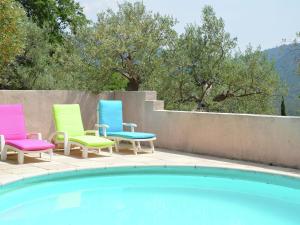 a group of chairs sitting next to a swimming pool at Modern villa with swimming pool in Bargemon in Bargemon