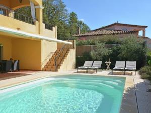a swimming pool with two chairs and a house at Spacious villa in Vidauban with seasonal private pool in Vidauban