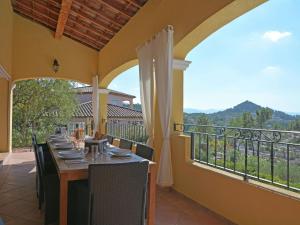 a dining room with a table and chairs on a balcony at Spacious villa in Vidauban with seasonal private pool in Vidauban