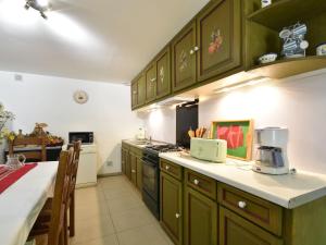a kitchen with green cabinets and a counter top at Superb holiday home with private garden in Yvias