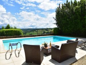 a large swimming pool with two chairs and a table at Sumptuous Mansion in Belves with Pool in Belvès