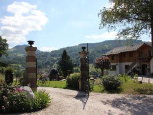 a gate to a house with a mountain in the background at Cozy chalet with a dishwasher, in the High Vosges in Le Ménil