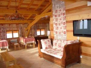 a living room with a couch and a tv at Chalet in Le Thillot with Skiing & Horse Riding Nearby in Le Ménil