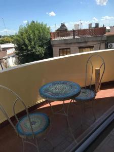 two chairs and two tables on a balcony at Excelente Departamento Centrico in San Pedro
