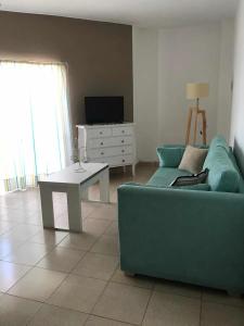 a living room with a blue couch and a table at Excelente Departamento Centrico in San Pedro