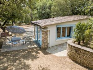 uma pequena casa com uma mesa e cadeiras num quintal em Adorable holiday home with pool em Uzer