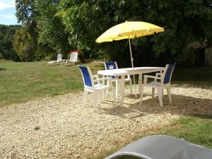a table and chairs with a yellow umbrella at Scenic Home in Berbiguières in Saint-Germain-de-Belvès