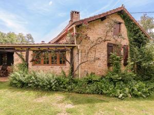 una vecchia casa di mattoni con edera che cresce sopra di Holiday Home in Dordogne near Lascaux Cave a Meyrals