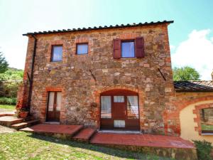 an old stone house with red doors and windows at Belvilla by OYO Casa Tiglio in San Quirico dʼOrcia