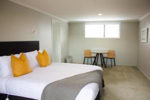 a bedroom with a bed with yellow pillows and a table at Twizel Central Studio Accommodation in Twizel