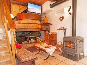 a living room with a fireplace and a stove at Charming Chalet in Champagny en Vanoise near Ski Area in Le Villard