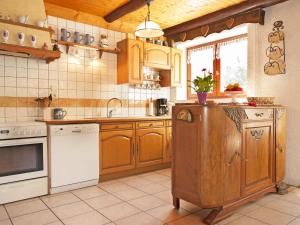 a kitchen with wooden cabinets and a white appliance at Charming Chalet in Champagny en Vanoise near Ski Area in Le Villard