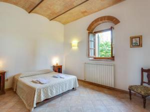 1 dormitorio con cama, ventana y silla en Belvilla by OYO Toraio, en Barberino di Val d'Elsa