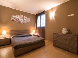 a bedroom with a bed and two night stands and a window at Belvilla by OYO Casa Giada in Marone