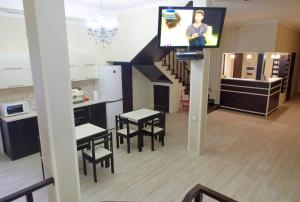 a living room with a table, chairs and a tv at New Life in Odesa