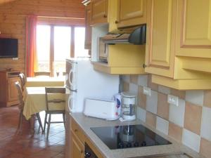 a kitchen with yellow cabinets and a table with a coffee maker at Cozy chalet with a dishwasher, in the High Vosges in Le Ménil