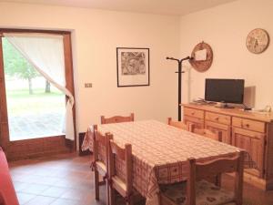 a dining room with a table and a computer monitor at Lovely Chalet in Pozza di Fassa with Garden in Pozza di Fassa