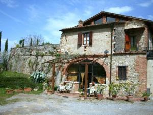 ラポラーノ・テルメにあるBelvilla by OYO Villa Rapolanoの古い石造りの家(テーブルと椅子付)