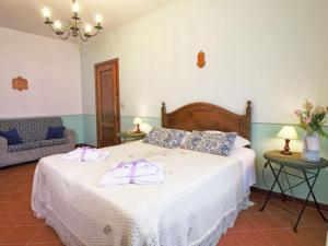 een slaapkamer met een bed met een witte sprei bij Belvilla by OYO Camillo Tosco in Valiano