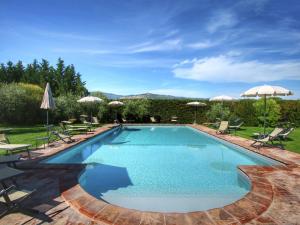 a swimming pool with chairs and umbrellas at Belvilla by OYO Cipresso in Cortona