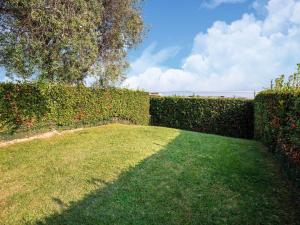 a garden with a hedge and a grassy yard at Belvilla by OYO Casa Mon ga in Moniga