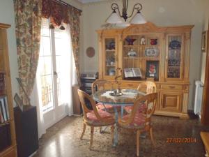 a dining room with a table and chairs and a cabinet at Casa Rural El Jarral in Jarafuel