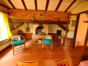 - un salon avec deux chaises et une cheminée dans l'établissement Belvilla by OYO Birilli, à San Marcello Pistoiese