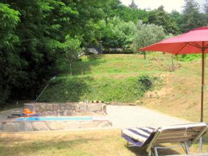 einen roten Regenschirm, zwei Stühle und einen Pool in der Unterkunft Belvilla by OYO Olivi Verde in San Quirico