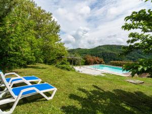 UzzanoにあるStunning house with pool and stunning rural viewsのスイミングプールの横に座る椅子