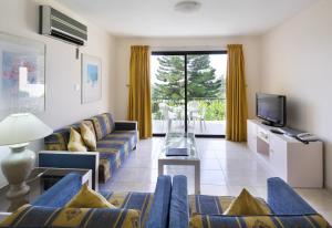 a living room with a couch and a tv at Club Aphrodite in Erimi