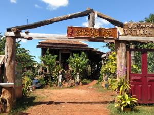 une entrée d'un village avec une porte rouge dans l'établissement Ratanak Tep Rithea homestay, à Banlung