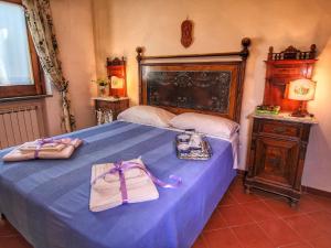 Un dormitorio con una cama azul con dos bolsas. en Belvilla by OYO Attractive mansion with pool en Valiano
