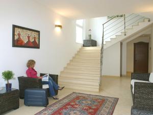 リッチョーネにあるQuiet Apartment near Riccione with Balconyの階段のある部屋の椅子に座る女性