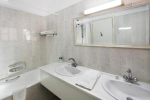 a white bathroom with a sink and a mirror at Club Aphrodite in Erimi