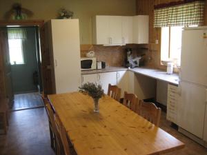 a kitchen with a wooden table with chairs and a refrigerator at Beautiful Holiday Home in Syssleb ck with Sauna in Sysslebäck