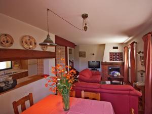 una sala de estar con un jarrón de flores sobre una mesa en Quinta Das Colmeias Cottage en Santo da Serra