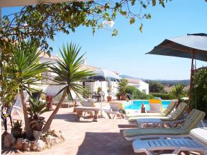 - un groupe de chaises longues et une piscine dans l'établissement Gorgeous Holiday Home with Swimming Pool, à Odiáxere